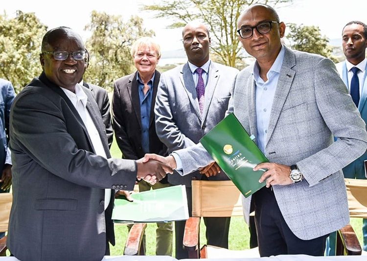 Oserian Two Lakes Industrial Park Finance Director Tim Ndikwe, left, and Maxim Agri Company GM Muhammad Salman, right, sign the investment witnessed by Nakuru Governor Lee Kinyanjui, centre.