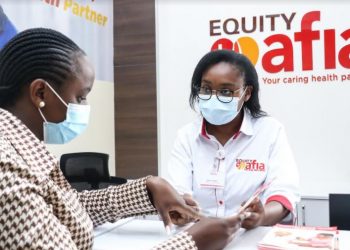 Equity Afia Front Office Representative Mary Kiruru (left) attends to a client at the Lavington Mall Medical Centre in Nairobi. Equity Afia has opened 6 additional medical centres in Ruai, Kariobangi, Lavington, Umoja, Kerugoya and Nanyuki bringing the franchise’s network to 53 medical centres.