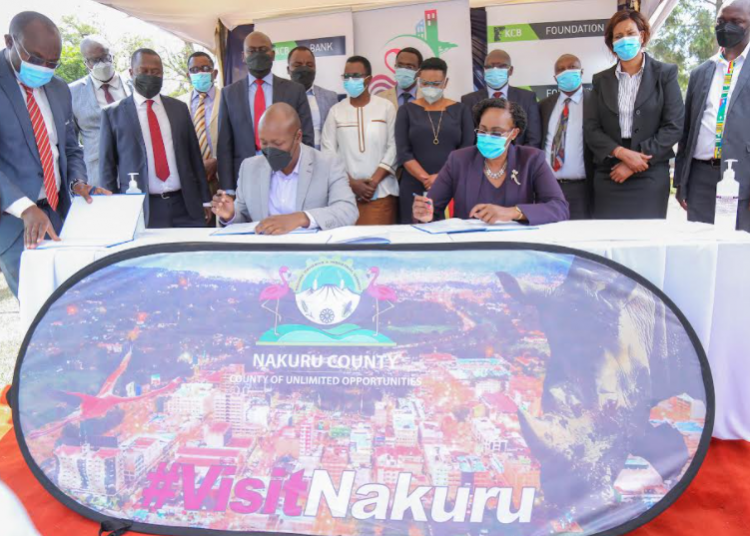 Nakuru Governor Lee Kinyanjui together with KCB Director Retail Banking, Anastacia Kimtai during the signing of MOU between Nakuru county government and KCB Bank on empowerment of Nakuru citizens and launch of Nakuru County Enterprise fund.