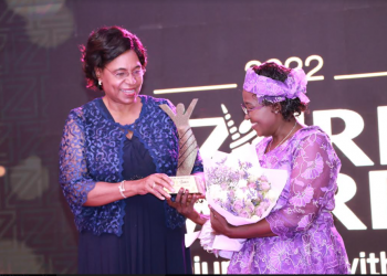 Margaret Kobia, Cabinet Secretary, Ministry of Public Service and Gender giving an award to Ruth Samoei for her role in facilitating disadvantaged deaf communities to favourably compete for available business opportunities in an already saturated market at the 2022 ZURI AWARDS held in Nairobi.